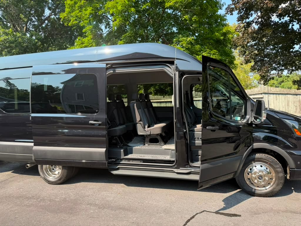 Ford passenger van exterior, side profile with the door open showing multi-row seating