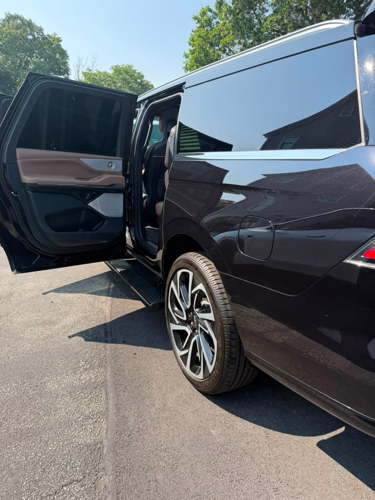Lincoln Navigator SUV limo (burgundy) exterior with door open, cognac leather interior visible
