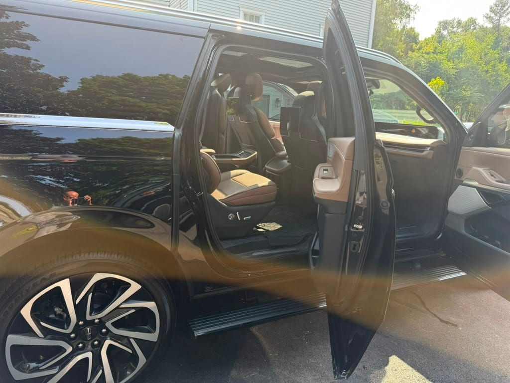 Lincoln Navigator SUV limo (black) with captain's-chair second-row seating, door open