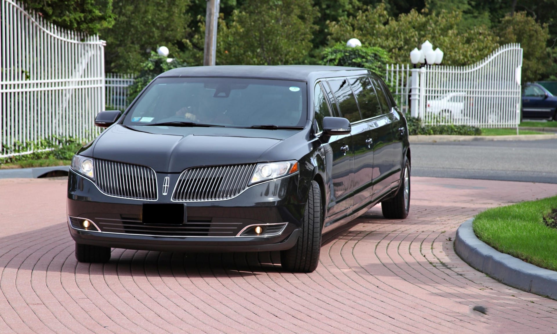 NY.Limo stretch limousine arriving curbside at night in the New York City metro area